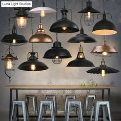 a bunch of lights hanging from the ceiling above a table with stools in front of it