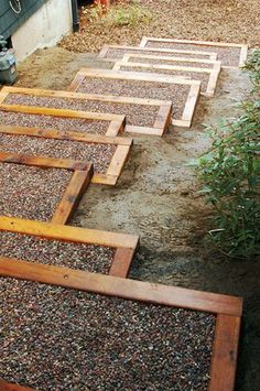 several wooden boards laying on top of each other in the dirt next to a building