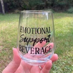 a person holding up a wine glass with the words'emotion support beverage'written on it