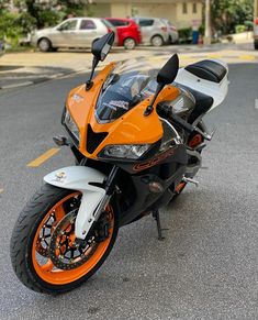 an orange and white motorcycle parked on the street