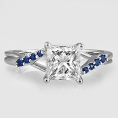 a princess cut diamond ring with blue sapphire accents