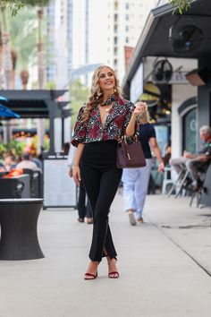 a woman is walking down the sidewalk with her hand in her pocket