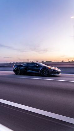 a black sports car driving down the highway