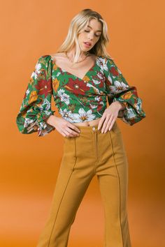 A printed woven top featuring surplice neckline, peasant sleeve and back zipper closure Details Self: 100% Polyester Lining: 100% Polyester Size & Fit - Model is 5`8" And Wearing Size Small - Measurements Taken From Size Small - Approx Length: 8"