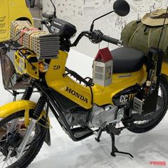 a yellow motorcycle parked next to a white wall