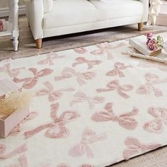 a living room with a white couch and pink rug