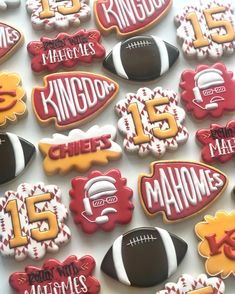 decorated cookies are arranged in the shape of footballs and helmets with names on them