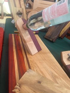 a wooden bench with wine bottle on top and other woodworking items in the background