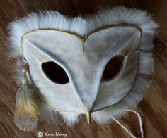 a white owl mask with feathers on it