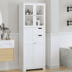 a white cabinet with glass doors in a bathroom