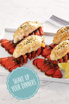 lobsters with lemon wedges on a white plate