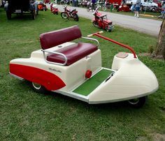 an old style scooter is parked in the grass