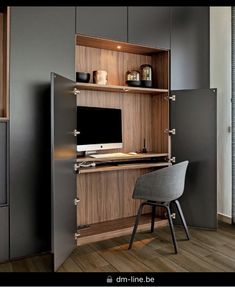 a computer desk with a chair in front of it and shelves on the wall behind it