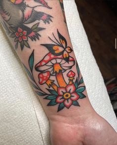 a woman's arm with flowers and birds tattoo on her left forearm, which is also in color