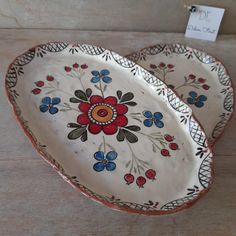 two decorative plates sitting on top of a wooden table