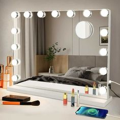 a mirror that is sitting on top of a table next to a phone and other items