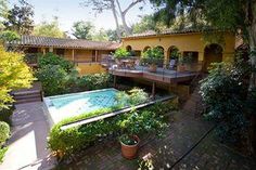 an outdoor swimming pool surrounded by trees and plants