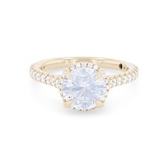 a yellow gold ring with an oval cut diamond in the center and pave set shoulders