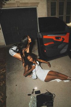 two women laying on the ground in front of a tv