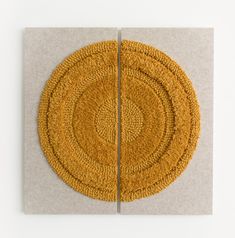 two circular rugs sitting on top of each other in front of a white wall