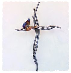 a cross made out of barbed wire with a butterfly on it