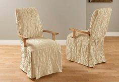 two chairs with covers on them sit in front of a wall and hardwood flooring