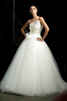 a woman in a white dress posing for the camera