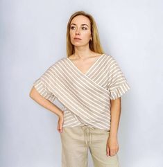 Striped linen top for women. Stylish, simple, elegant linen blouse in a loose and casual style that you can wear on many occasions.  DETAILS: - 100% linen fabric (European, softened, 170-205/m2).  - Relaxed fit  - Roll up kimono sleeves - Asymmetrical hem/ tulip hem  - CUSTOM ORDERS AVAILABLE. We can add length to a garment or make it shorter.  SIZING: - Please, refer to your body measurements (before purchasing) in our size chart as the picture of this listing.  🛑 SIZE CHART IS THE BODY MEASUR Beige Linen Tops For Vacation, Summer Linen Blouse With Relaxed Fit, Casual Linen V-neck Blouse, Effortless Linen V-neck Blouse, Relaxed Fit Linen Summer Blouse, Elegant Linen Blouse For Vacation, Chic Summer Linen Blouse, Effortless Short Sleeve Beach Tops, Chic Beige Linen Blouse