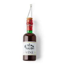 a bottle of wine hanging from a string on a white wall with a red and green label