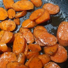 some cooked carrots are being fried in a pan with water on the stove top