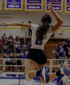 a woman jumping in the air to hit a volleyball