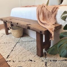 a wooden bench sitting on top of a white rug