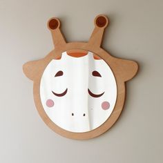 a wooden wall hanging with a face shaped like a giraffe