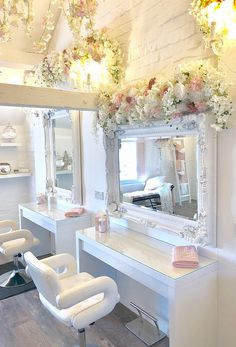 a salon with white chairs and flowers on the wall