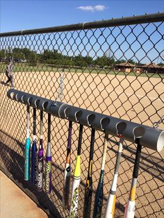 baseball bats are lined up on the fence