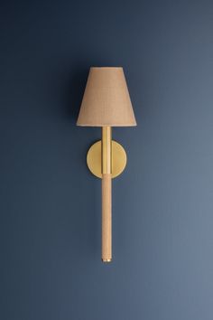 a lamp on the wall next to a blue wall