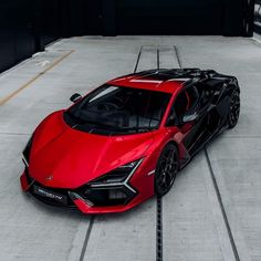 a red sports car is parked on the concrete