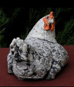 a close up of a rock with a chicken on it