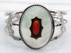 Add a touch of Native American charm with this playful sterling silver cuff bracelet featuring a vibrant mother of pearl and coral design. Stand out from the crowd with a piece that is as unique as you are! Metal: Sterling SilverGem: Mother of PearlGem Measurements: 37.8 x 27.5 mm, OvalAccents: CoralWidth: 2 InchesInside Circumference: 5 InchesGap Measurements: 1 1/2 Inches Coral Design, Coral Bracelet, Design Stand, Sterling Silver Cuff Bracelet, Sterling Silver Cuff, Silver Cuff Bracelet, American Jewelry, Native American Jewelry, Silver Cuff