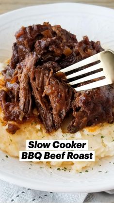 crockpot tender bbq beef roast on top of mashed potatoes with a fork