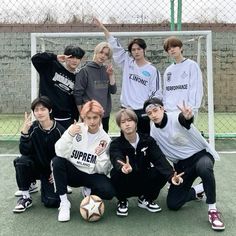 a group of young men standing next to each other on top of a soccer field