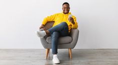 a man sitting in a chair holding a cell phone