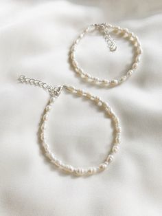 "Freshwater pearls are one of a kind so will differ from those shown in the photos.  ∙ S I Z E ∙ G U I D E ∙ We recommend that you take your own measurement before purchasing but if that is not possible, here is a rough size guide below.  Exchanges are always welcome if the fit is not perfect!   6\" - bracelet suitable for adults with small wrists  7\" - bracelet suitable for most adults   8\" - anklet suitable for adults with small ankles  9\" - anklet suitable for most adults 10\" - anklet suitable for adults with wider ankles    Each item comes with an additional 1\" extension chain on top of your selected length.    For example, if you select the 6\" option, the total length will be approximately 7\" including the clasp and extension chain.  M A T E R I A L S ∙    Durable steel cord, f Plain Beaded Bracelets, Handmade Minimalist Pearl Beaded Bracelets, Pearl White Bracelet With Sterling Silver Clasp As Gift, Adjustable White Pearl Bracelet In Sterling Silver, Adjustable White Sterling Silver Pearl Bracelet, Minimalist Single Strand Pearl Bracelet For Gift, Classic Handmade Pearl Bracelet With Round Beads, Handmade Pearl White Everyday Pearl Bracelet, White Single Strand Pearl Beaded Bracelet