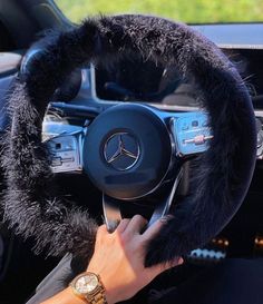 a person driving a car with a steering wheel cover