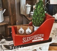 there is a red sleigh with two earrings on it and a potted plant