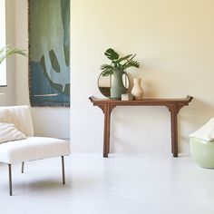 a chair and table in a room with a painting on the wall next to it