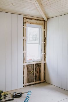 an unfinished room with white walls and wood framing