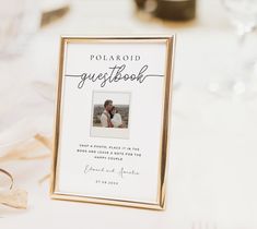 a polaroid guest book sitting on top of a table next to wine glasses and napkins