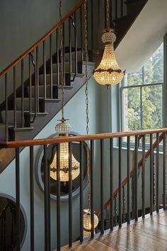 two chandeliers hanging from the railing of a staircase