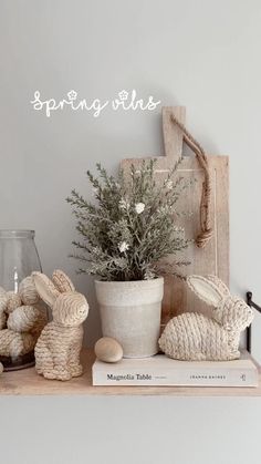 a shelf with some bunny figurines and a potted plant sitting on top of it